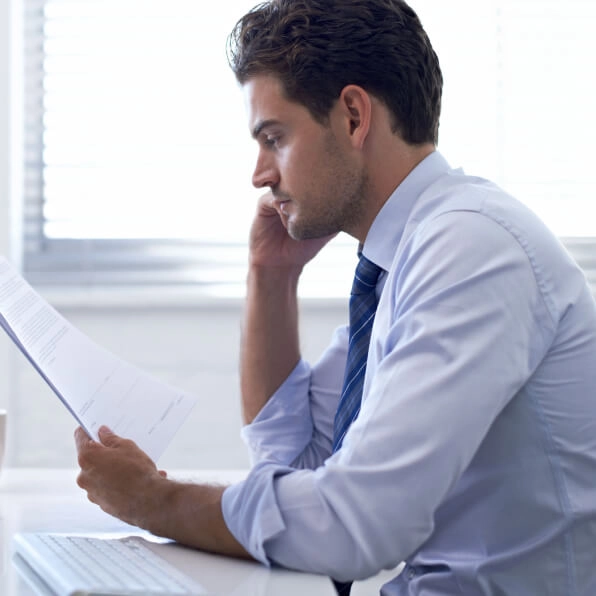 Man in suit looking at piece of paper